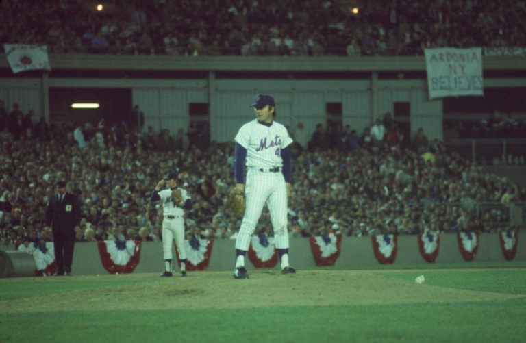 Wayne Garrett on the Mound as Sign in Background Reads 